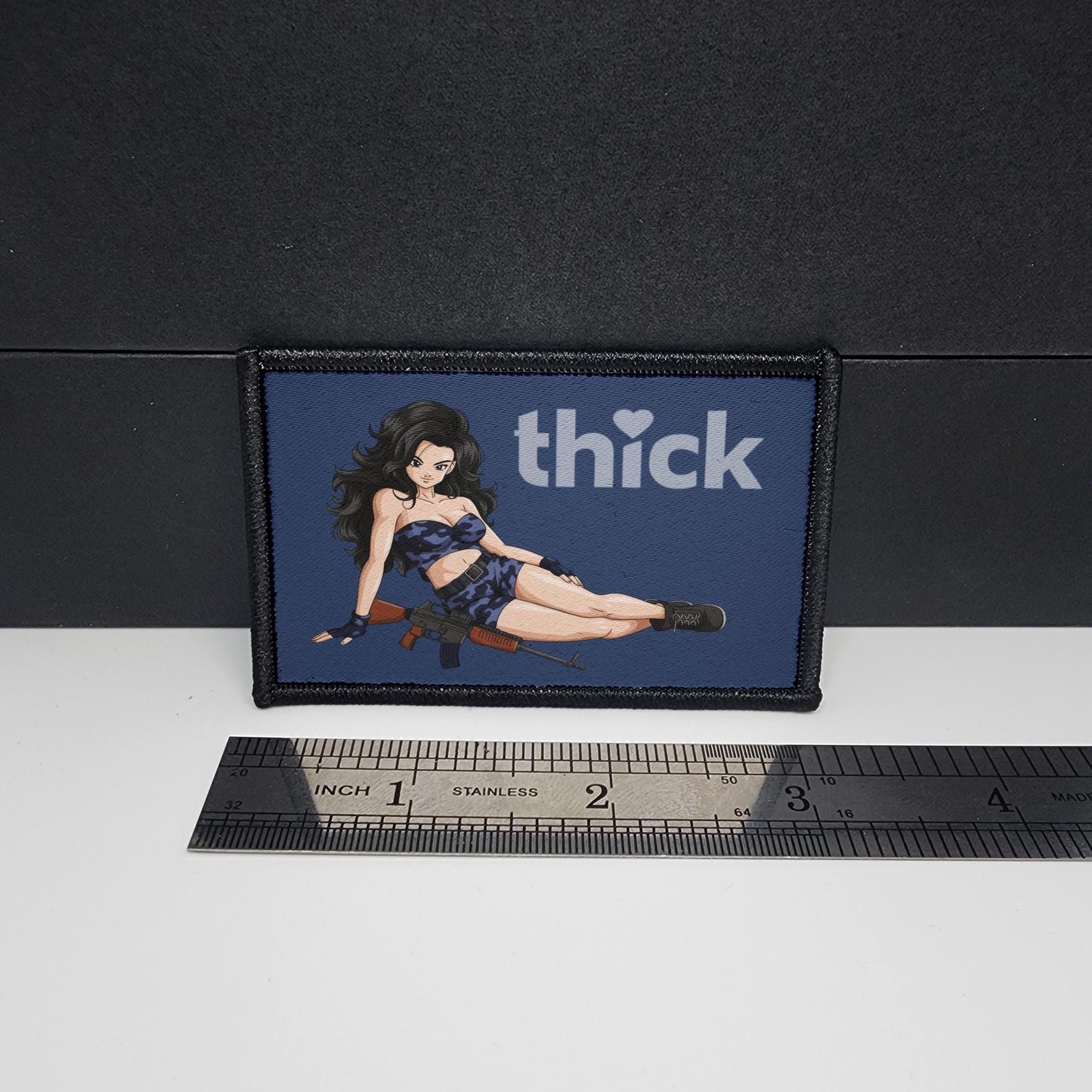 Patch with a graphic of a woman and the word 'thick' next to a ruler for scale on a black background.
Thick Hearts – morale patch – sexy - anime - waifu - video game - 2x3 inch – hook and loop - iron-on – interchangeable patch hat - navy waifu