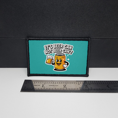 Teal patch with cartoon beer mug design and text, placed on a black surface with a ruler for scale.