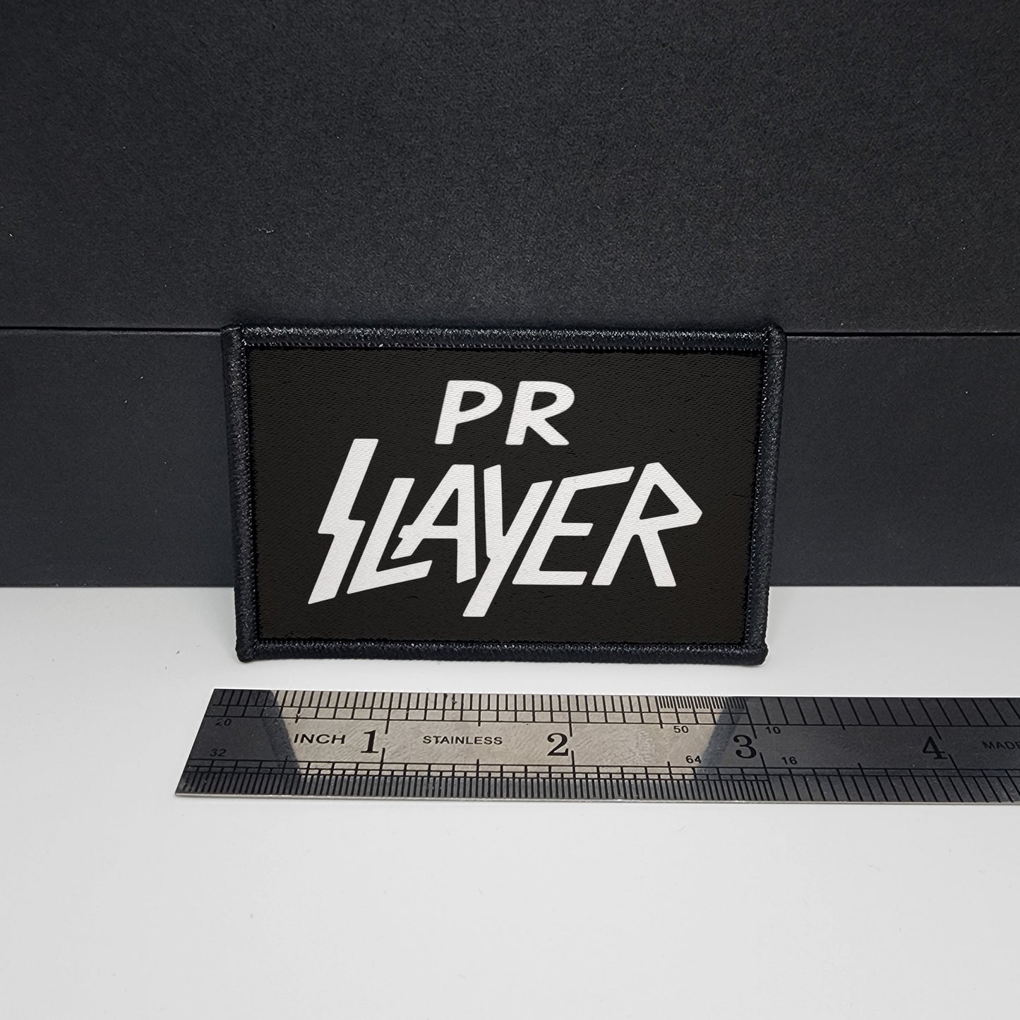 Black patch with 'PR Slayer' text on a white surface with a ruler for scale.

CAPS LOCK ORIGINAL - morale patch - 2x3 inch – hook and loop - iron-on - interchangeable patch - hat - bag - sports